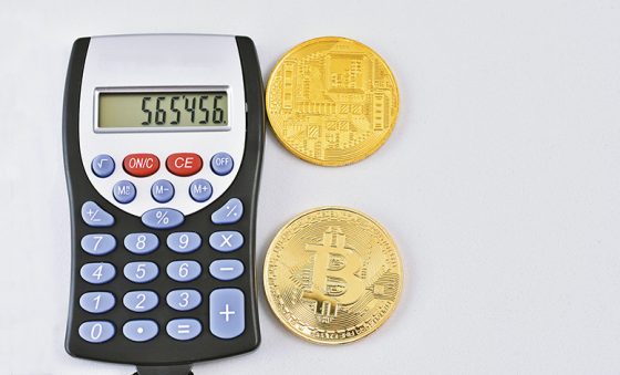  | calculadora sobre dinero con billetes, monedas y bitcoins