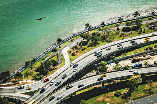  | Cars driving on highway near ocean coast - city traffic aerial